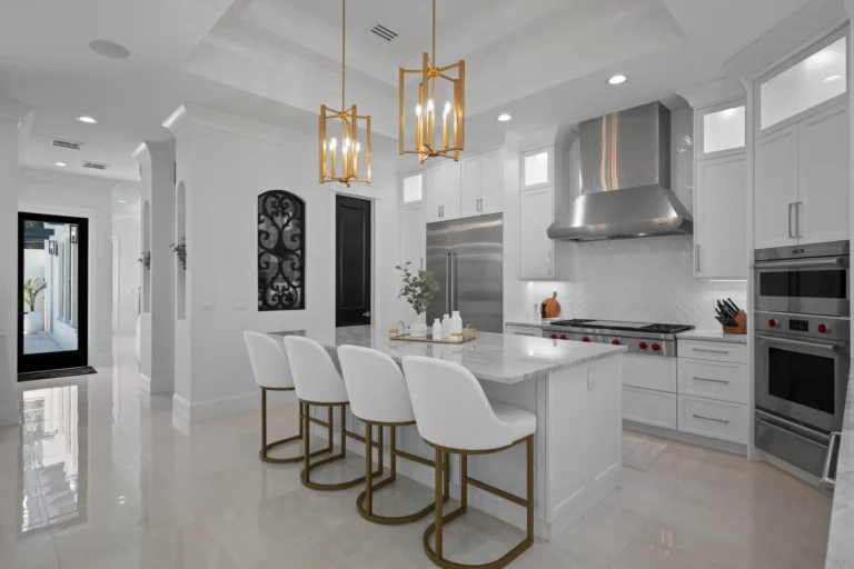 Modern white kitchen with waterfall quartz island and gold pendant lighting by Halo Industrial