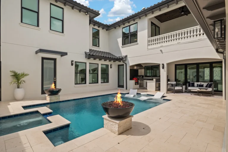 Rear exterior of a Halo Industrial custom home in Tampa Bay with a screened pool, spa and fire bowls